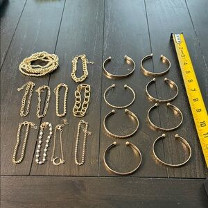 Random assortment of 22 gold and white bracelets